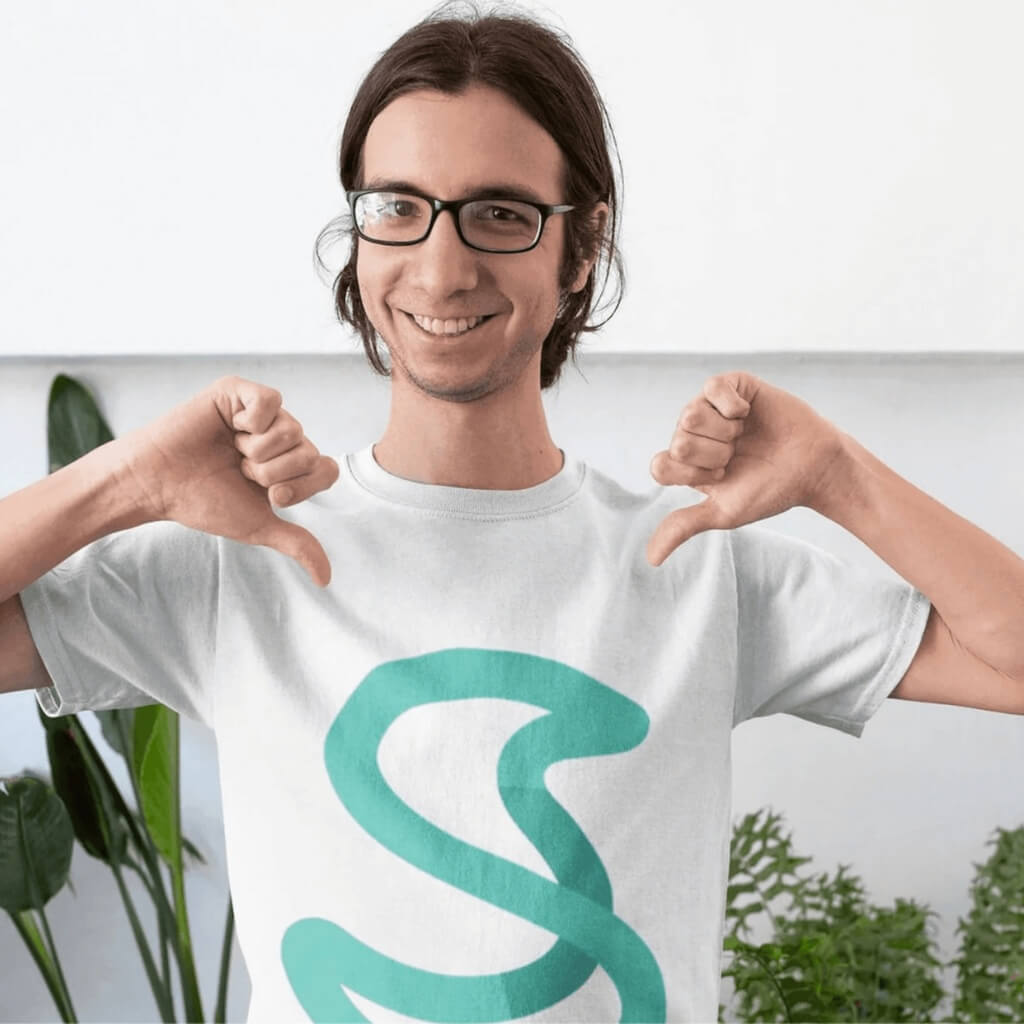 Membro del team che sorride e indica con i pollici il logo “S” di Simple Budget Excel sulla maglietta. Immagine di branding positivo e coinvolgimento del team.