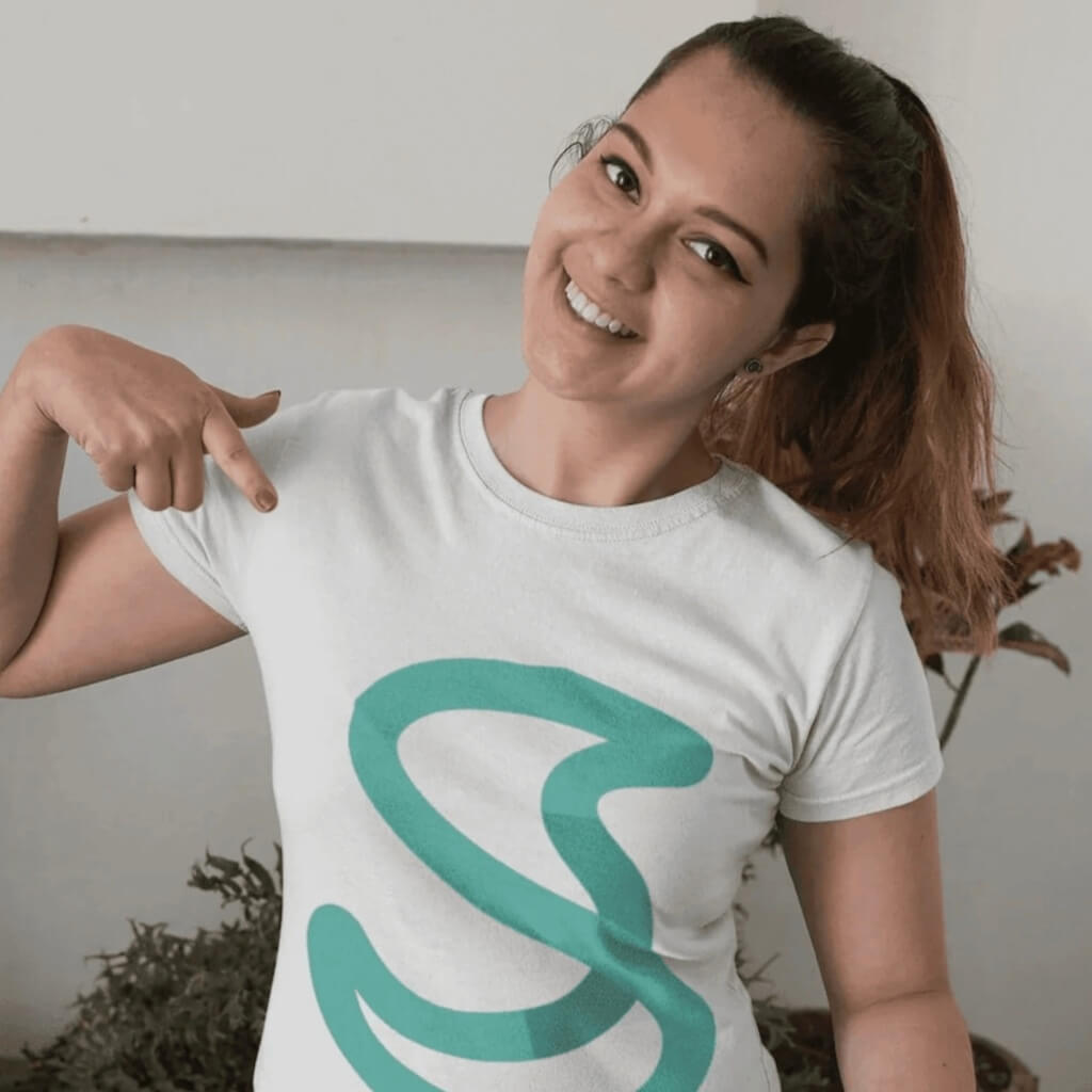 Donna sorridente che indossa una maglietta con logo “S” stilizzato, simbolo del brand Simple Budget Excel. Immagine di branding positivo e identità visiva.